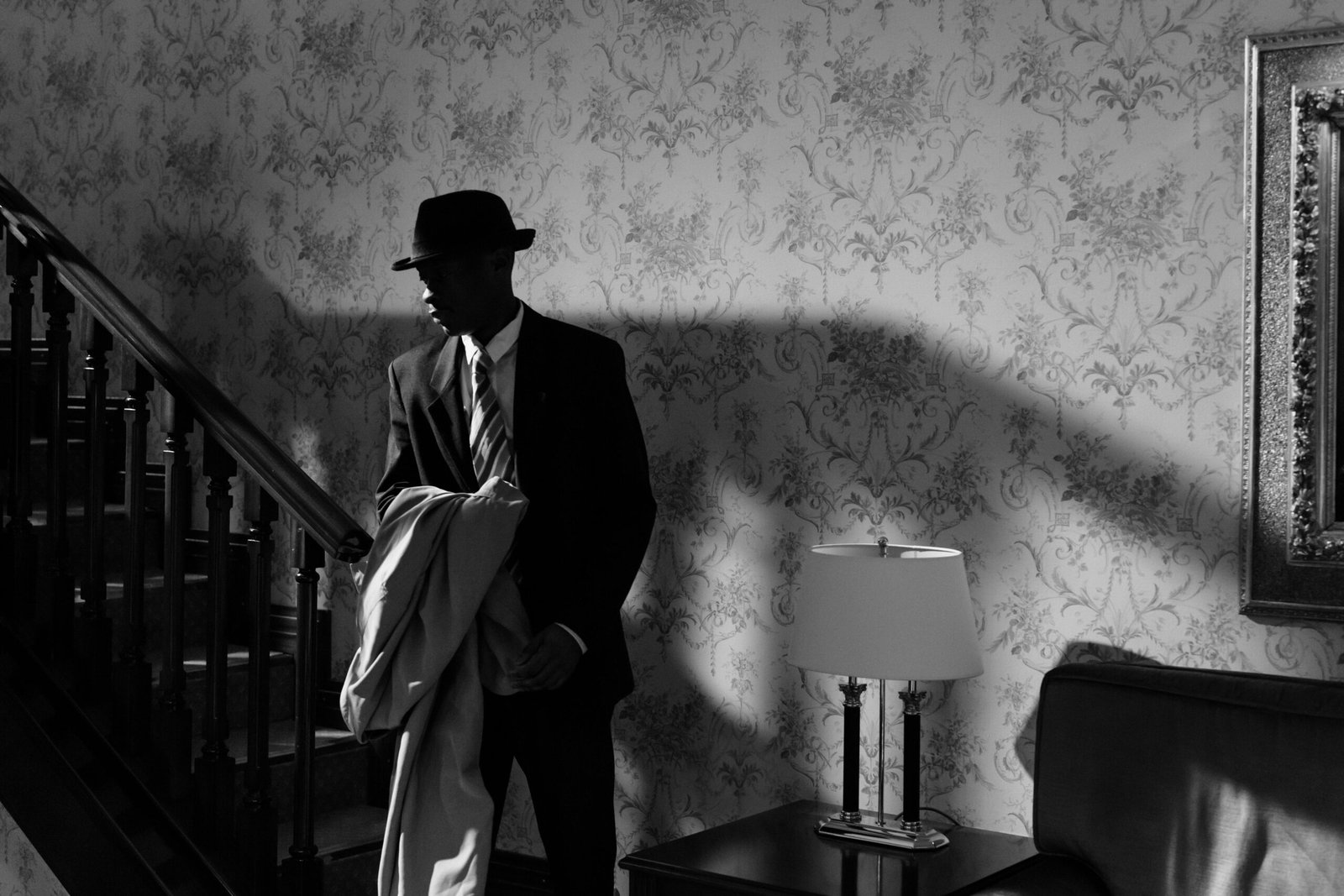 A black and white scene of a detective in a vintage interior, exuding mystery and intrigue.